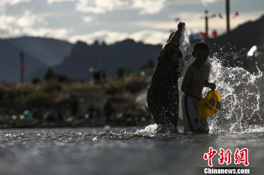 图为藏族民众在拉萨河沐浴. 何蓬磊 摄